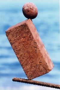 Stone and brick balanced on rod