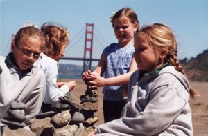 More girls at the beach balancing rocks